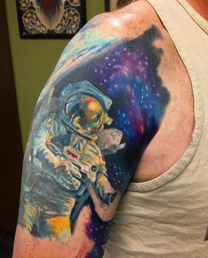 Full color astronaut in space partial upper sleeve tattoo by tattoo artist Russ Howie of Sacred Mandala Studio in Durham, NC.